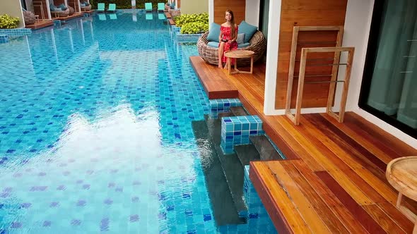 Drone Flying Over Swimming Pool in Luxury Hotel Beautiful Woman in Red Dress