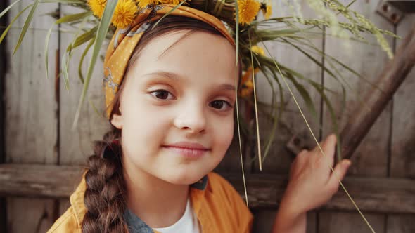 Pretty Girl in Flower Wreath Posing for Camera in Farm