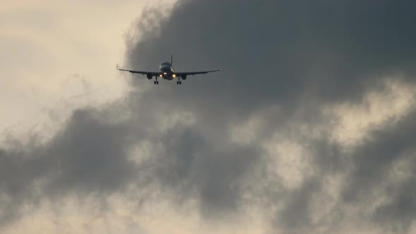 Airplane Landing on the Background of the Cloudy Sky