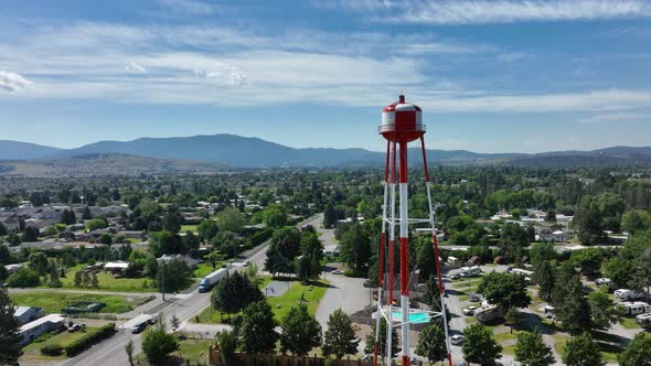 Orbiting drone shot of a tall water tower in middle class America.