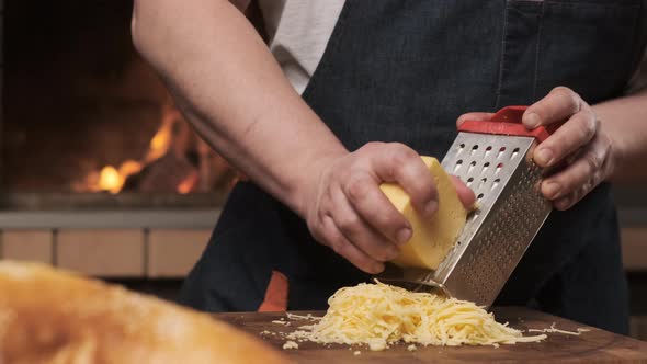 Male Chef Rubscheese on Iron Grater