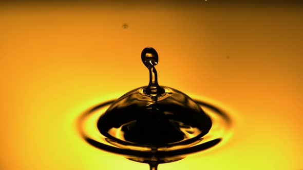 Drop Of Fuel Oil Dripping And Creating Bubble On The Yellow Surface