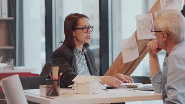 Young Female Architect Discussing Project with Senior Male Colleague