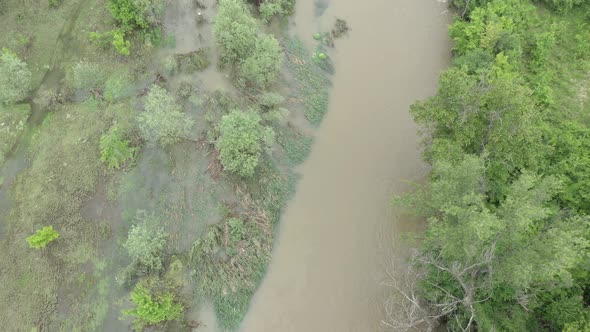 Flooding affects coastal area of narrow river 4K aerial footage