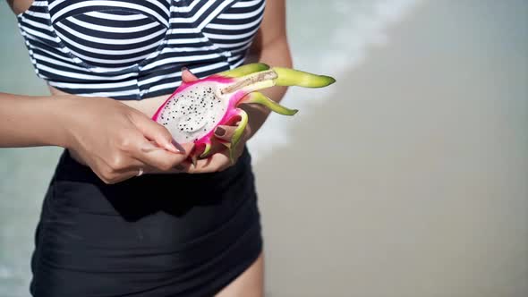 Woman Eating Dragon Fruit with a Spoon