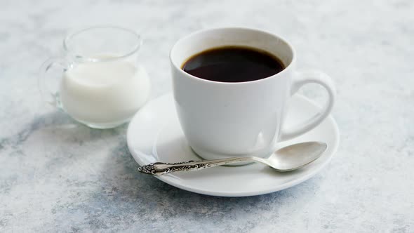 Cup of Coffee and Pitcher of Milk