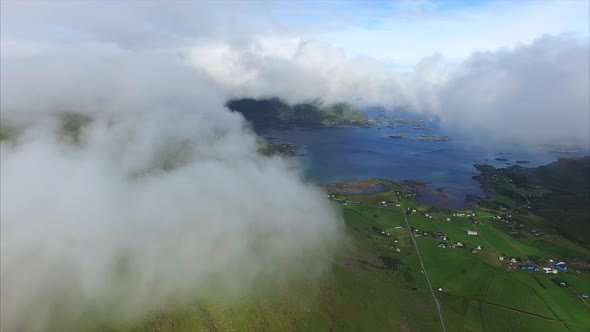 Fast moving clouds on green mountain slope, aerial view