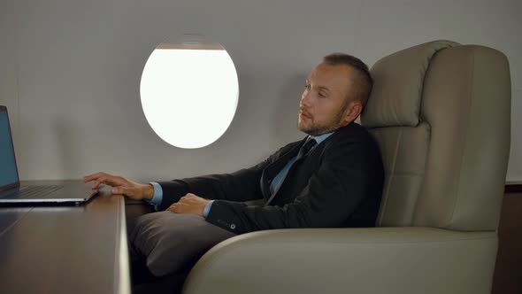 Rich Entrepreneur Working on Notebook Inside of Luxury Jet