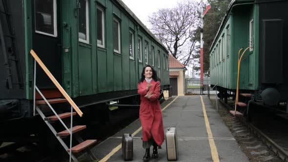 Funny Video a Woman in a Red Coat and Two Suitcases Is Dancing on the Platform of the Old Railway