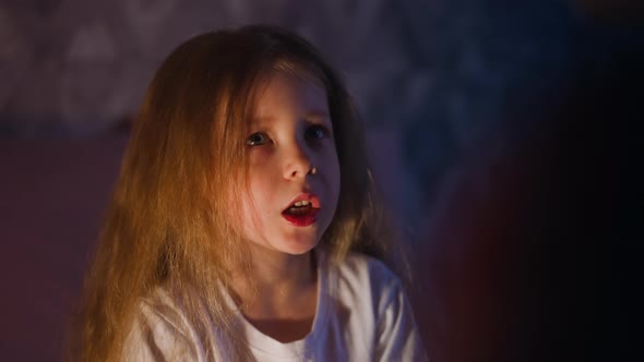 Little Daughter Talks to Parent in Semidark Room at Night