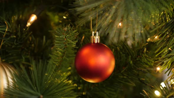 Red bauble hanged on the artificial tree 4K 2160p 30fps UltraHD footage - Fairy-lights and Christmas