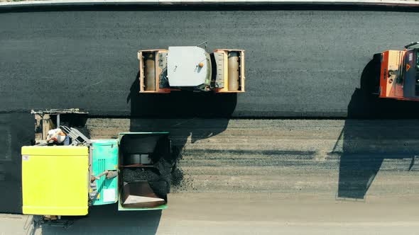 Road Construction Process. Bitum Spreading Machines on the Motorway in a Top View