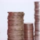 A woman's hand puts coins in a column. Investment concept. Metallic currency. Close-up action. - VideoHive Item for Sale