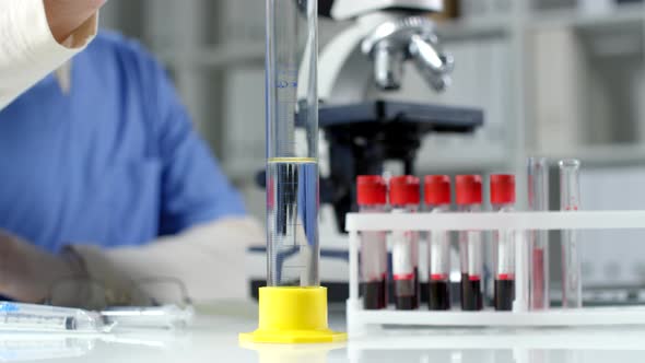Scientist Pouring Reagent into Liquid Substance in Test Tube alt