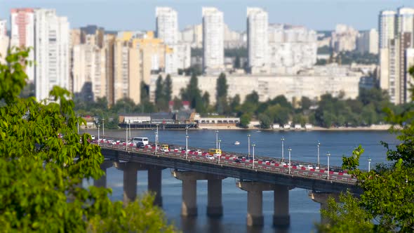 View of the Paton Bridge with Movement of Cars and Trucks on the City Road in Time Lapse 