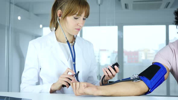 Doctor Checking Blood Pressure of Patient in Clinic