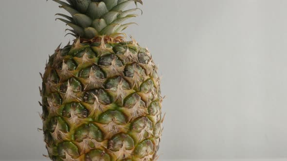 Close-up of exotic pineapple on white slow tilt 4K 2160p 30fps UltraHD  footage - Tilting on Ananas 