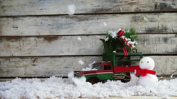 Toy car carrying fir with snowman