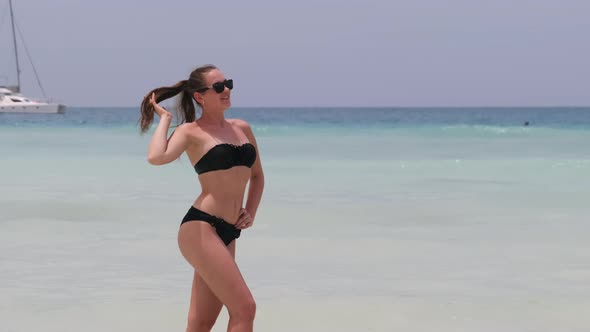 Young Woman in a Bikini Posing on Exotic Beach at the Turquoise Ocean Zanzibar