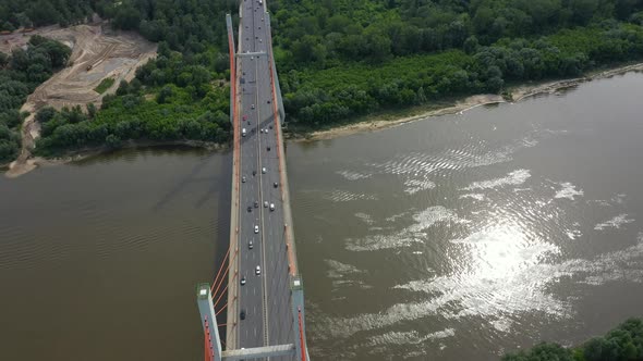 Aerial shooting from flying drone car traffic on modern highway bridge over river