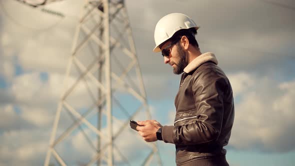 Electrical Engineer In Helmet Power Line. Constructor Checking High Voltage Sensor Power Line Wires.