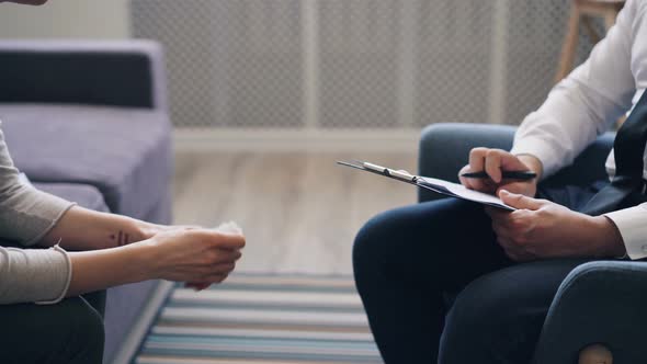 Female Patient Gesturing During Conversation with Psychologist in Modern Office