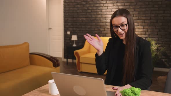 Young Happy Businesswoman in Glasses Communicating By Video Call on Laptop