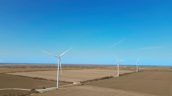 Aerial View of Wind Turbine Farm on Agriculture Fields in Ukraine on Clear Blue Sky Background