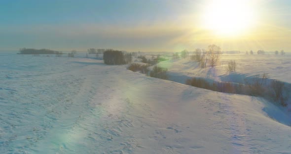 Aerial View of Cold Winter Landscape Arctic Field Trees Covered with Frost Snow Ice River and Sun