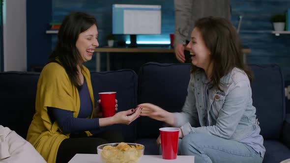 Happy Women Enjoying Friendship with High Five Late at Night in Living Room