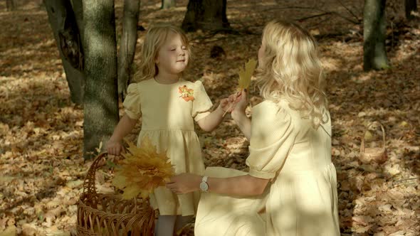 Happy Young Mother with Daughter in Autumn Park