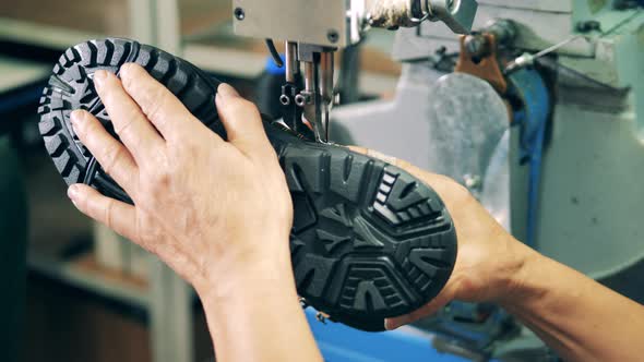 Factory Worker Is Stitching a Boot with a Sewing Machine
