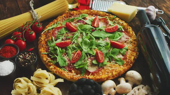 Italian Food Background with Pizza, Raw Pasta and Vegetables on Wooden Table