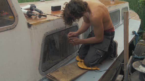 Scraping old silicone sealant from windows of old timber boat