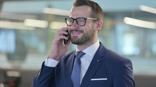 Portrait of Middle Aged Businessman Talking on Smartphone