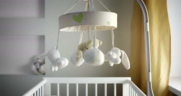 Baby Mobile with Different Animals Hanging Over the Child Crib of a Newborn