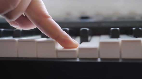 Electronic piano. Fingers press the piano keys. Music lesson.