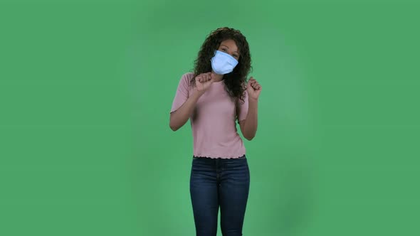 Portrait of Beautiful African American Young Woman in Medical Mask Is Looking Straight and Is