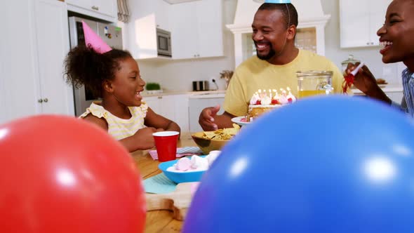 Family celebrating a birthday in kitchen at home