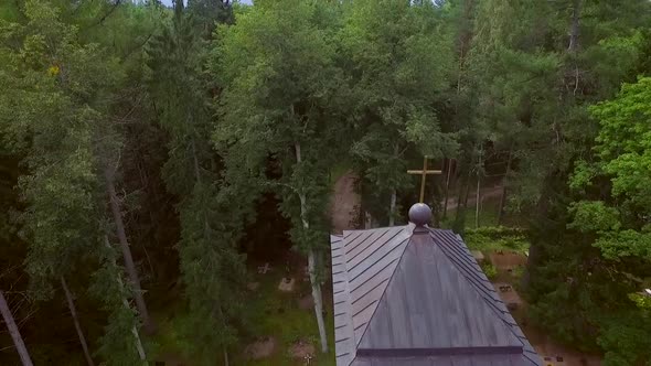 Aerial view of a forest with traditional Chapel and a cemetery in Estonia.