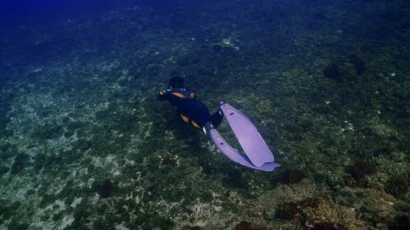 Underwater shot of a freediver swimming in the depth of the mediterranean sea in slow motion.