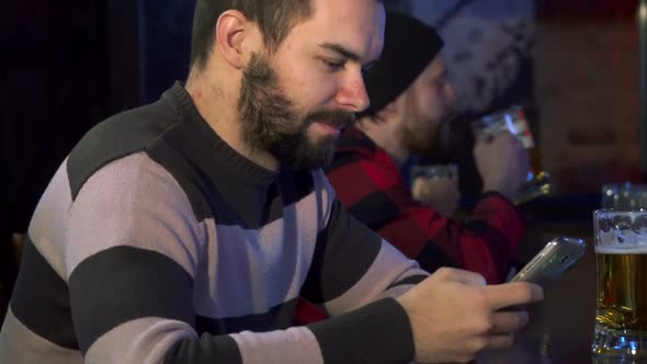 Man Flips on His Smartphone at the Pub