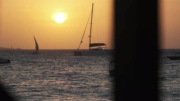 Silhouette Yacht with High Mast Sails at Sunset in the Ocean Zanzibar Africa