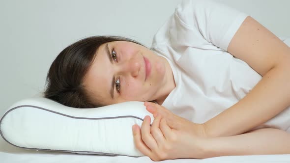 A Woman Goes to Bed on Her Favorite Orthopedic Pillow Smiles Closes Her Eyes and Falls Asleep