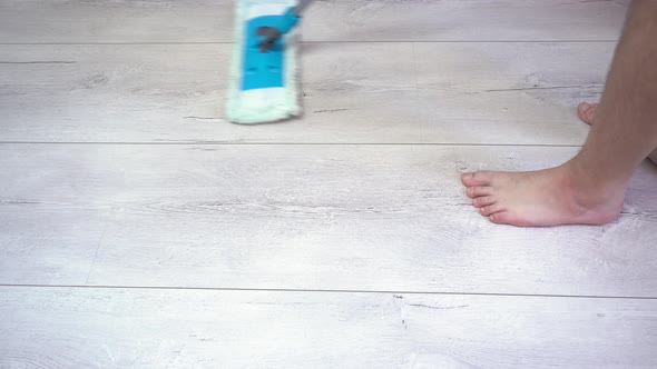 Man Cleaning Floors with Mop on Gray Laminate Surface