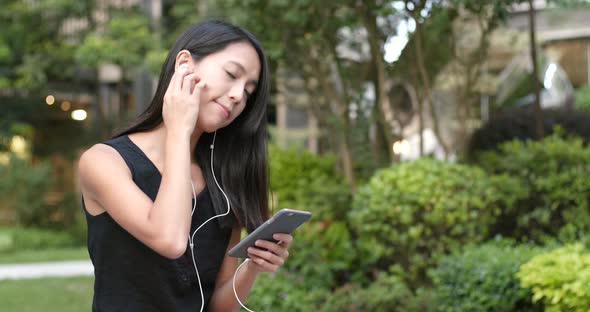 Woman listen to music on cellphone with earphone