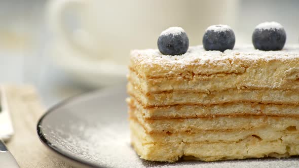 Cream Puff Pastry Napoleon Cake, Covered with Icing Sugar and Decorated with Four Blueberries