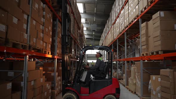 Male Employee Working on Loader in Factory Storage