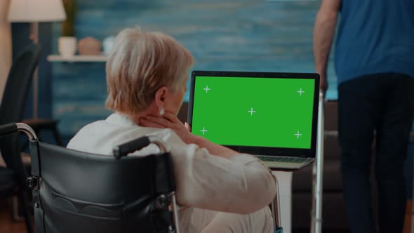 Old Person Holding Laptop with Green Screen Background