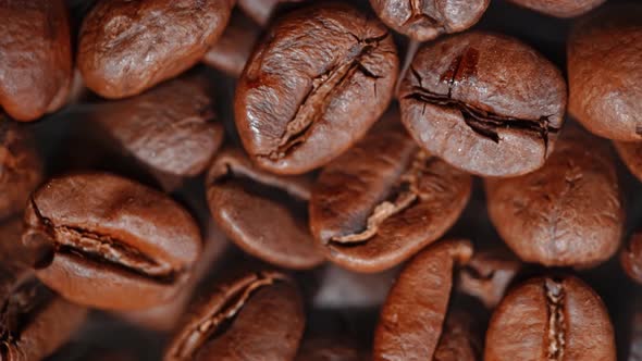 Close Up of Seeds of Coffee. Fragrant Coffee Beans Are Roasted Smoke Comes From Coffee Beans.